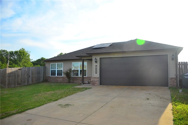 view of front of house with a front yard, a garage, and solar panels