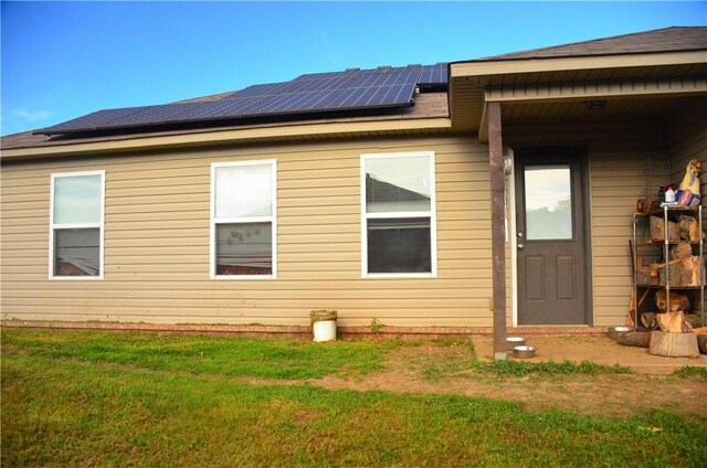 view of home's exterior with a yard and solar panels