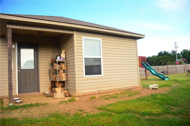 view of home's exterior with a playground and a yard