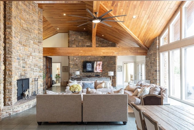 tiled living room featuring wooden ceiling, ceiling fan, a stone fireplace, and high vaulted ceiling