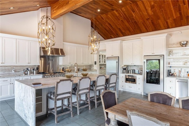 kitchen with white cabinetry, wooden ceiling, stainless steel appliances, pendant lighting, and light stone counters