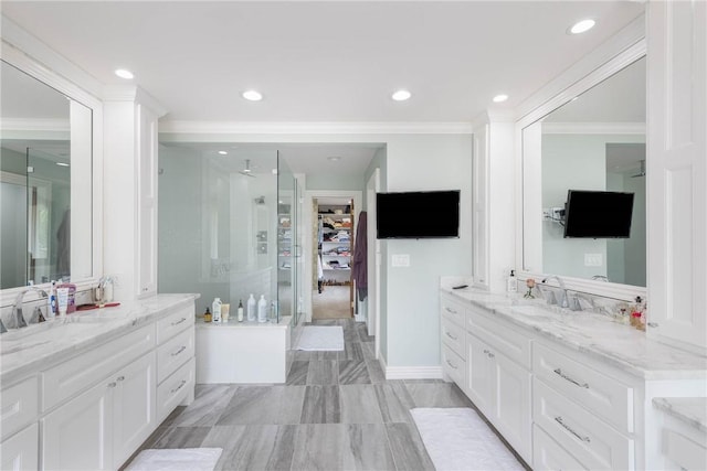 bathroom with a shower with door, vanity, and crown molding