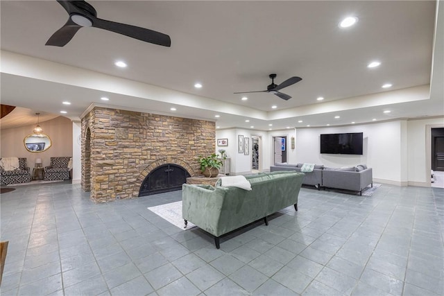 living room featuring ceiling fan, light tile patterned flooring, and a fireplace