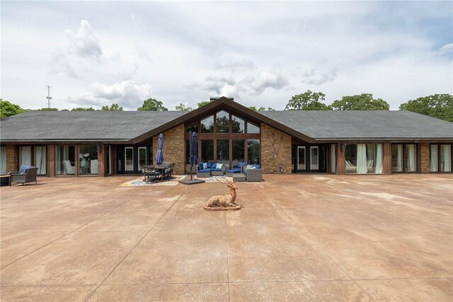 back of property featuring an outdoor living space and a patio