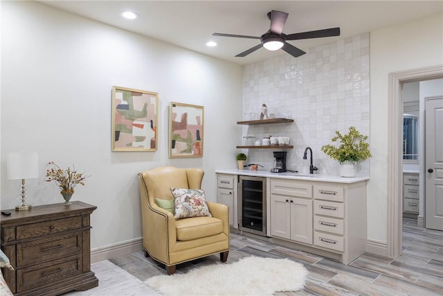 bar featuring white cabinets, wine cooler, decorative backsplash, sink, and ceiling fan