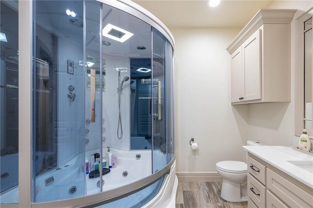 full bathroom featuring enclosed tub / shower combo, vanity, and toilet