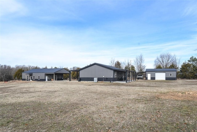 ranch-style house with a garage, an outdoor structure, and a front lawn