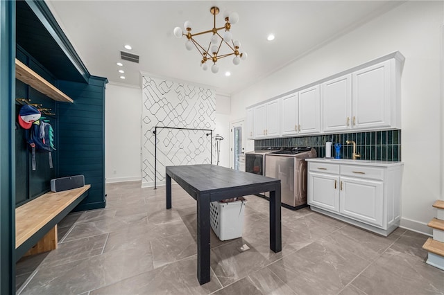 laundry area featuring washer and clothes dryer, cabinet space, ornamental molding, a chandelier, and recessed lighting