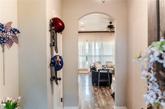 corridor with a textured ceiling and hardwood / wood-style flooring