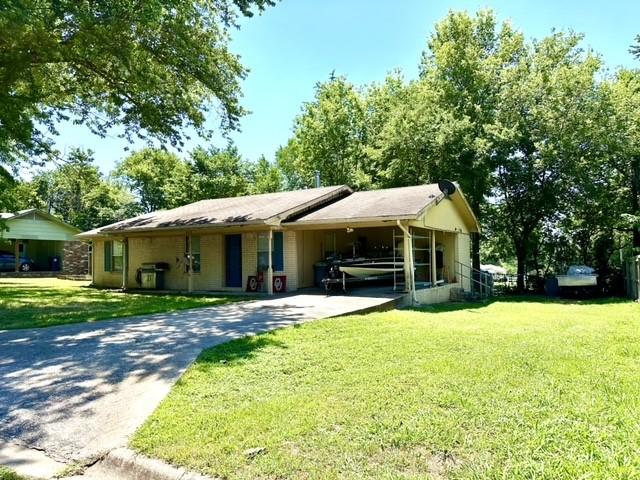 ranch-style house with a carport and a front yard