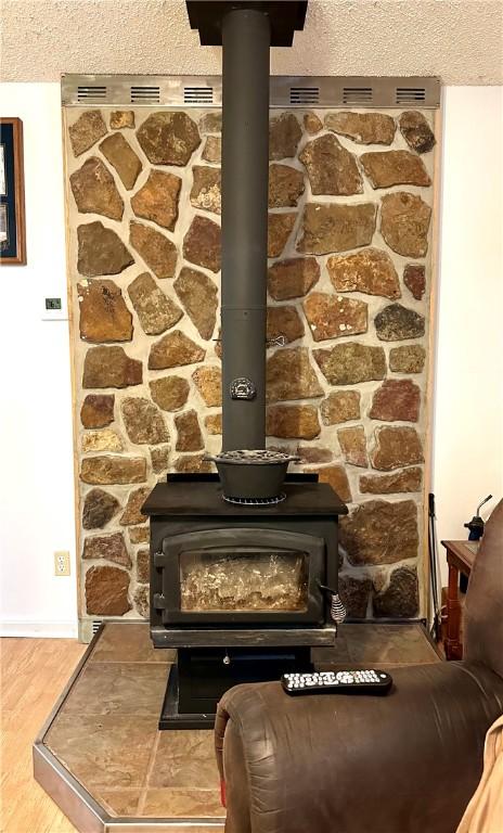 details with a wood stove and wood-type flooring