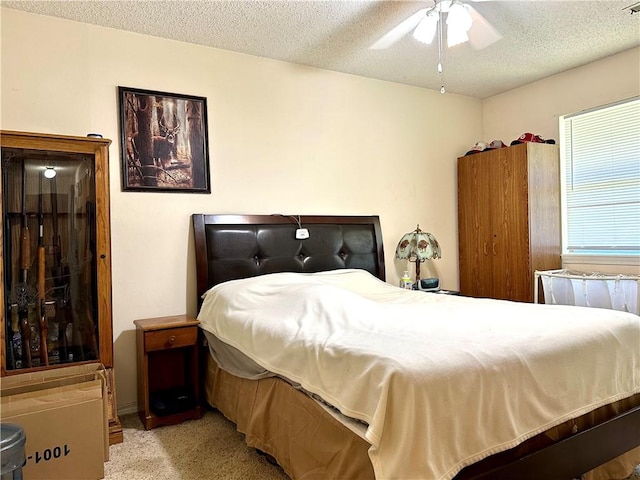 carpeted bedroom featuring ceiling fan and a textured ceiling