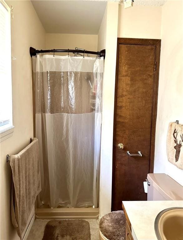 bathroom with toilet, vanity, and curtained shower