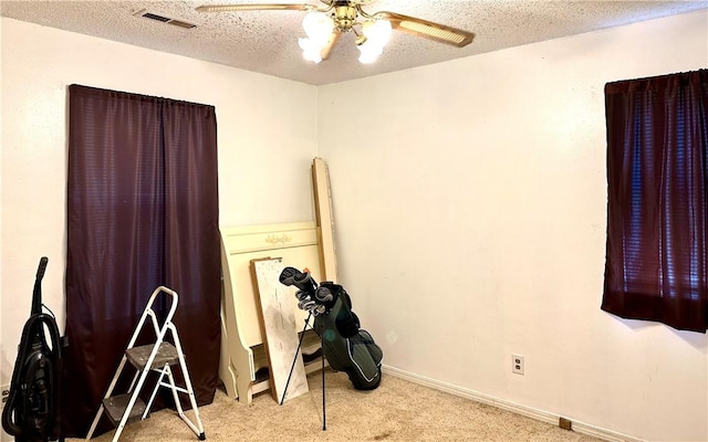 interior space with ceiling fan, a textured ceiling, and light carpet