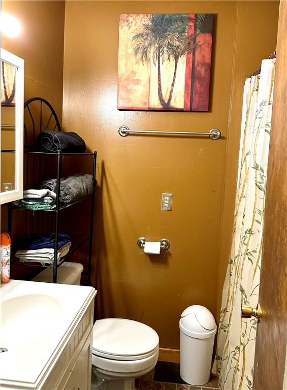 bathroom with toilet, tile patterned floors, and vanity