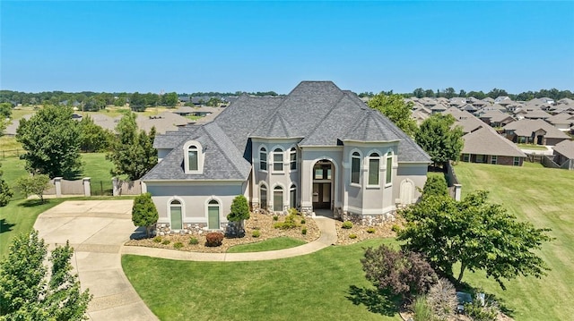 french provincial home with a front yard