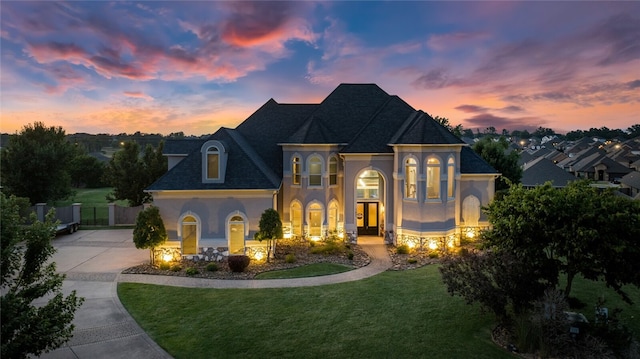 french provincial home with a lawn