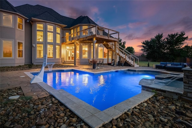 pool at dusk with a patio area and an outdoor hangout area