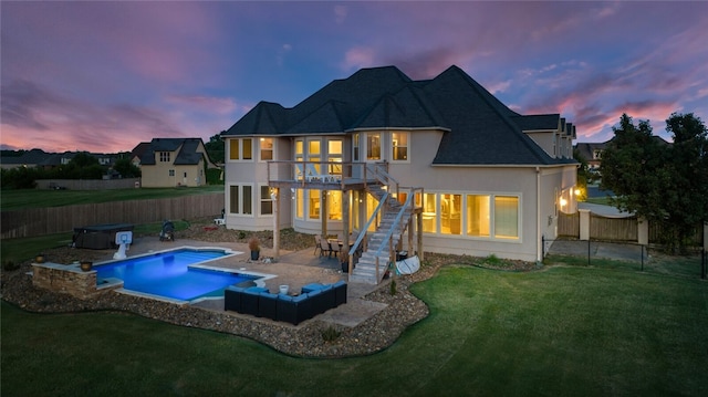 back house at dusk featuring a lawn, outdoor lounge area, and a patio