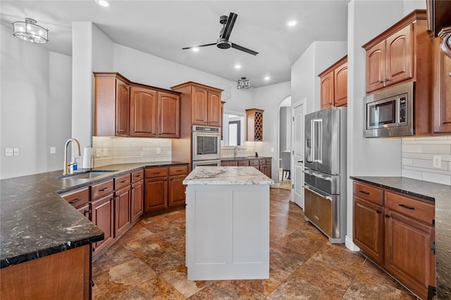 kitchen featuring backsplash, sink, a center island, and stainless steel appliances