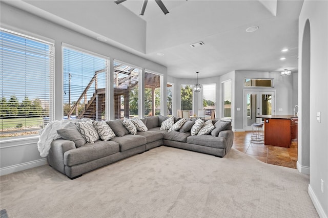 carpeted living room with ceiling fan and french doors