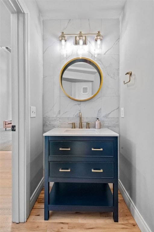 bathroom with vanity, wood-type flooring, and tile walls