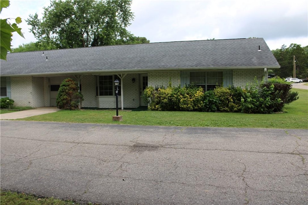 single story home with a carport and a front yard