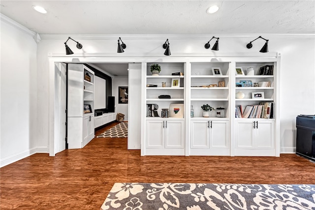 bar with dark wood-type flooring, ornamental molding, and white cabinetry