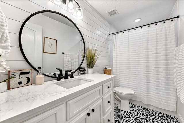 bathroom with toilet, wood walls, tile patterned floors, vanity, and curtained shower