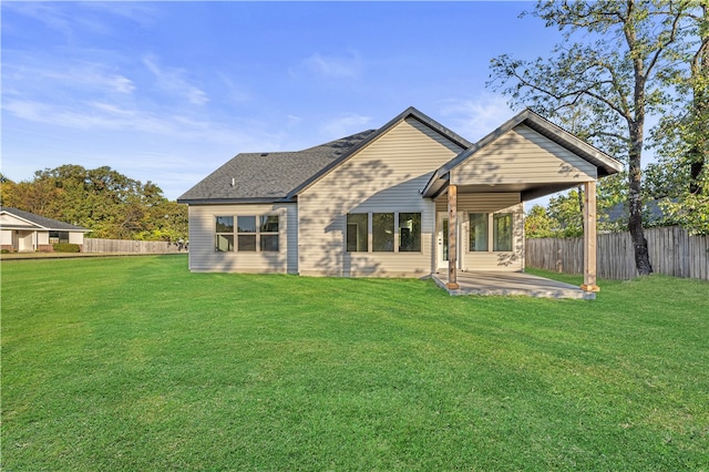 rear view of property featuring a patio area and a yard