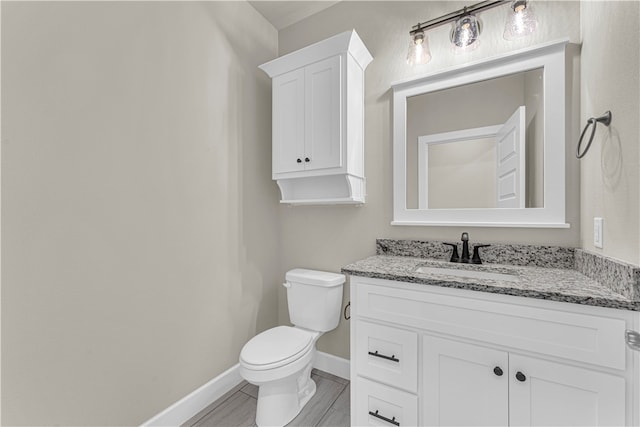 bathroom featuring vanity, wood-type flooring, and toilet