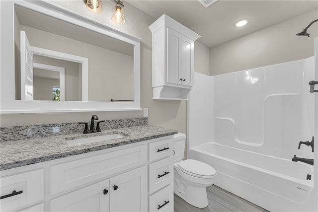 full bathroom featuring shower / bathing tub combination, hardwood / wood-style floors, vanity, and toilet