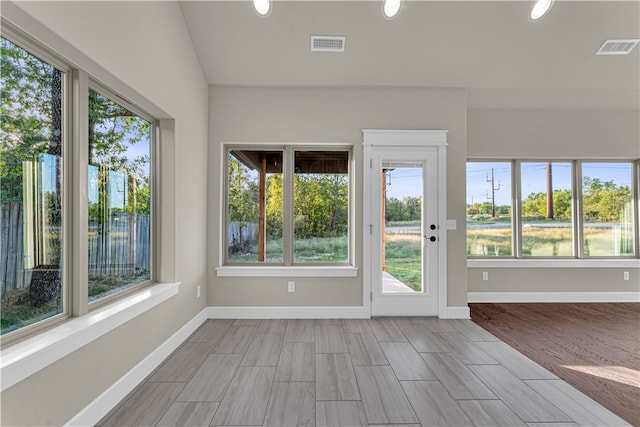 unfurnished sunroom featuring a healthy amount of sunlight and lofted ceiling