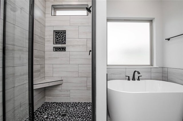 bathroom featuring a soaking tub and a stall shower