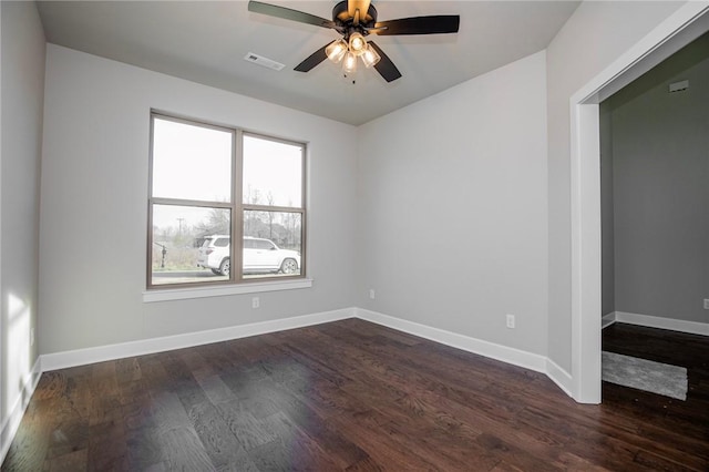 empty room with baseboards, a ceiling fan, dark wood-style floors, and visible vents