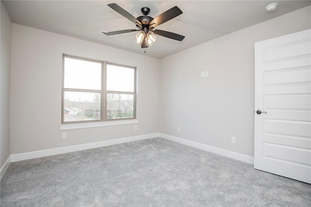 carpeted empty room featuring baseboards and ceiling fan