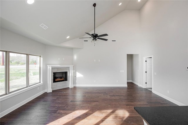 unfurnished living room featuring dark wood-style flooring, a fireplace, ceiling fan, high vaulted ceiling, and recessed lighting