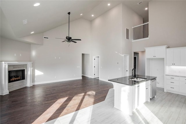 kitchen with ceiling fan, a sink, dishwasher, high vaulted ceiling, and open floor plan