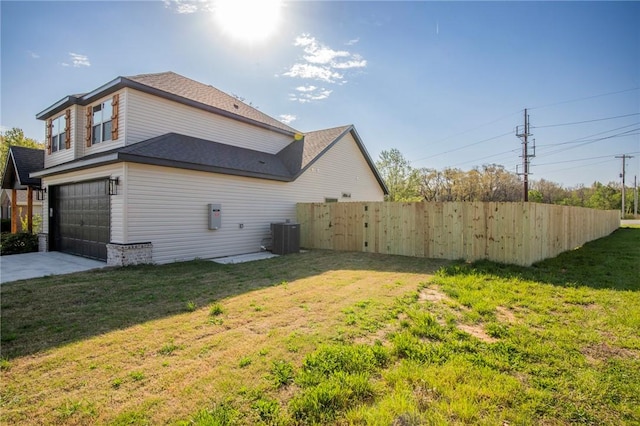 view of home's exterior featuring a garage, fence, cooling unit, concrete driveway, and a lawn