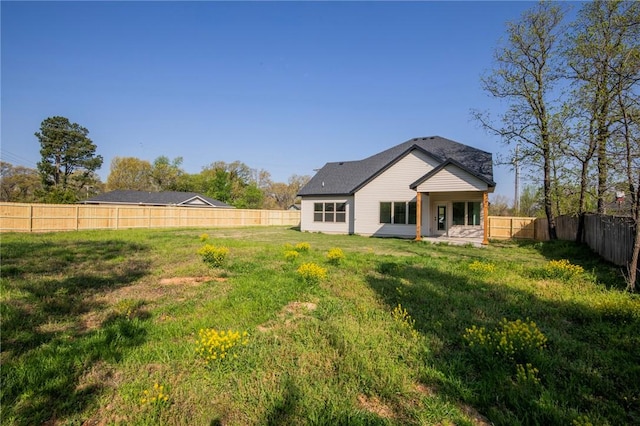 back of property featuring a yard, a fenced backyard, and a patio area
