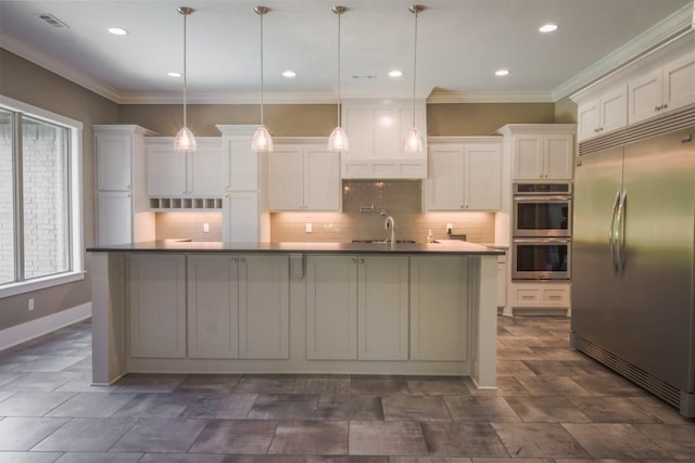 kitchen featuring white cabinetry, hanging light fixtures, stainless steel appliances, crown molding, and an island with sink