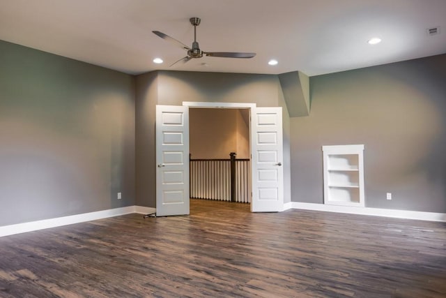 unfurnished room featuring built in shelves, dark hardwood / wood-style floors, and ceiling fan