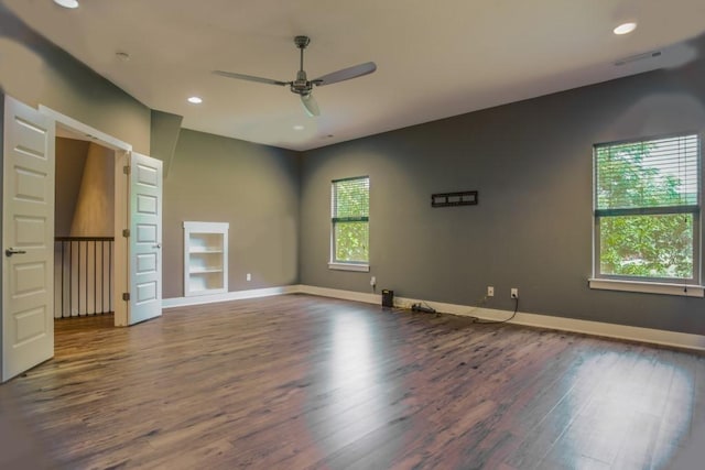 unfurnished room with built in shelves, ceiling fan, and dark hardwood / wood-style flooring