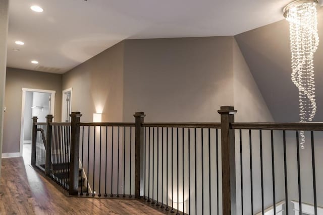 corridor with a notable chandelier and wood-type flooring