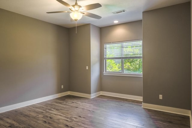 unfurnished room with ceiling fan and dark wood-type flooring