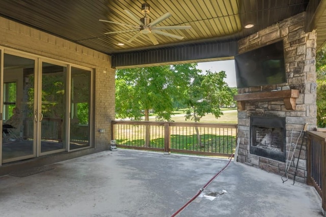 view of patio / terrace featuring ceiling fan and an outdoor stone fireplace