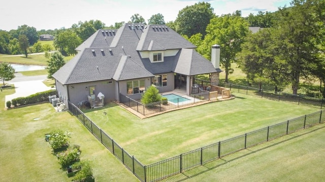 back of property featuring a lawn, a water view, and a patio