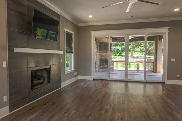 unfurnished living room with dark wood-type flooring, crown molding, and a tiled fireplace