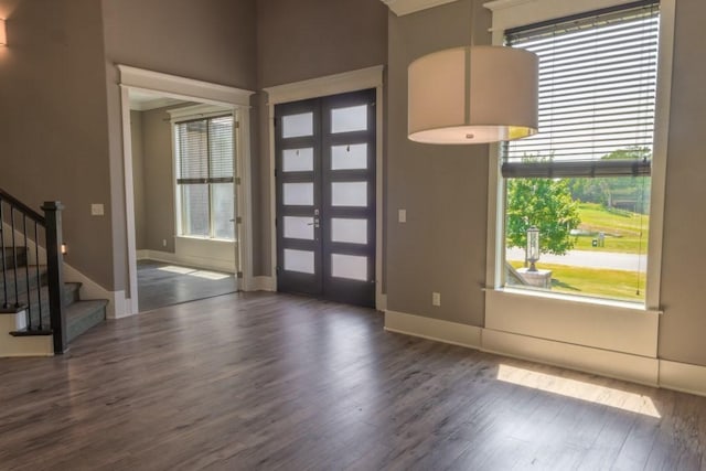 foyer entrance with french doors and dark hardwood / wood-style floors