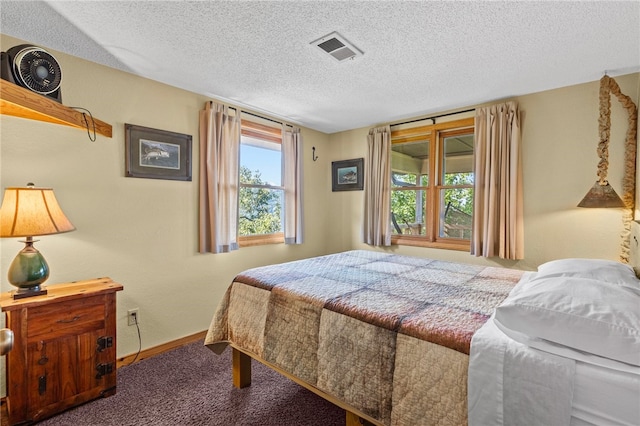 bedroom featuring a textured ceiling, carpet flooring, and multiple windows